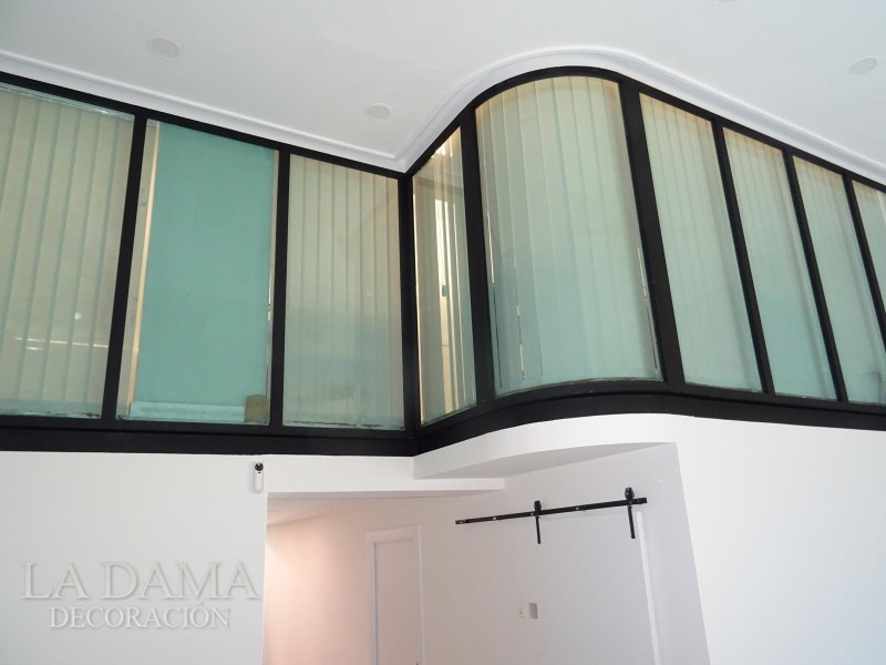 Lamas verticales para una oficina con ventanas arqueadas