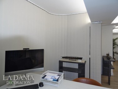 Cortina de lamas verticales con ventanas curvas en oficina